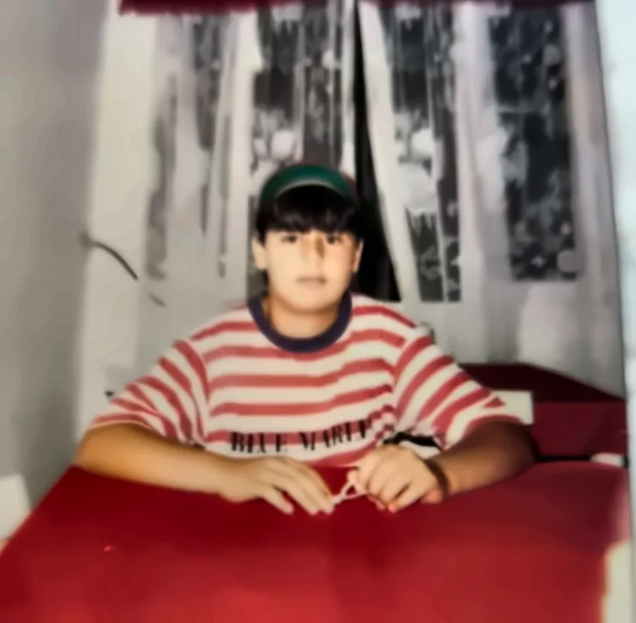 Robson aos 13 anos sentado à mesa do restaurante da família, em 1994